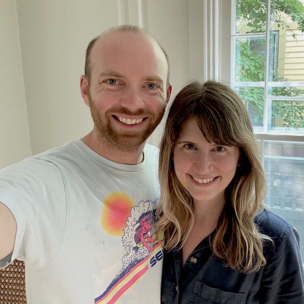 Hayes-Window-Restoration-McCormick-Drinan-Profile-1-SQ Happy couple smiling indoors by window.