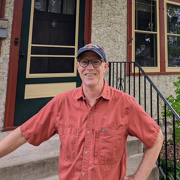 Hayes-Window-Restoration-Longfellow-Johnson-Profile-SQ Man in red shirt smiling outside a house.