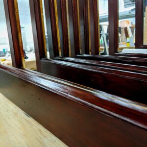 Close-up of glossy wooden stair rails in workshop.