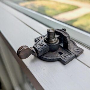 Vintage window lock on wooden frame.