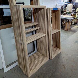 Wooden modular bookshelves in workshop setting.
