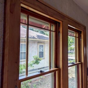 Wood-framed windows overlooking suburban neighborhood.
