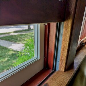 Colorful open window showing outdoor greenery.