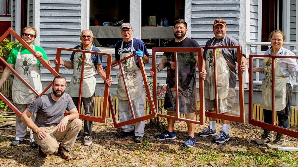 Group holding window frames during community service project