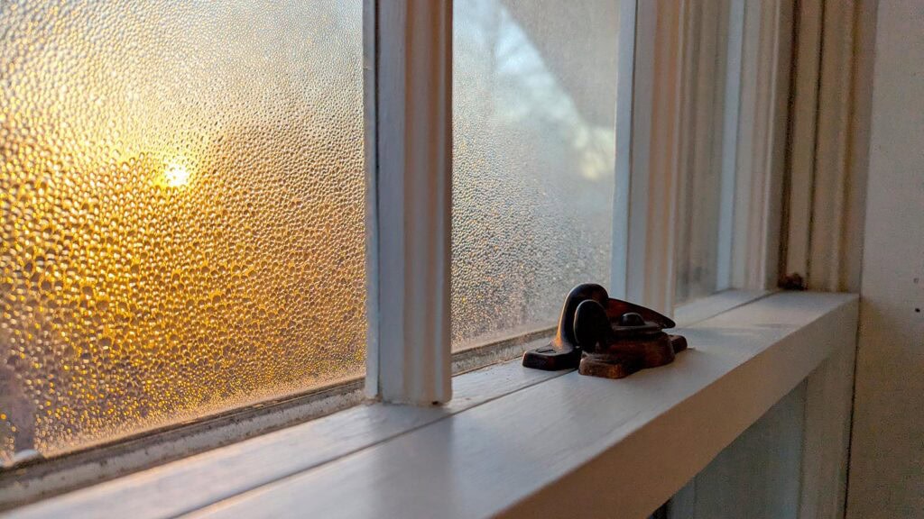 Sunrise through textured glass window with lock