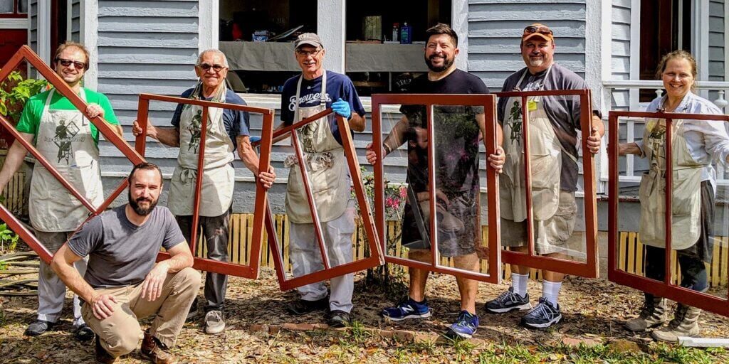 Group holding window frames during community service project