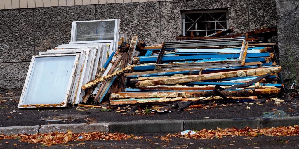 Discarded wooden boards and windows by building.